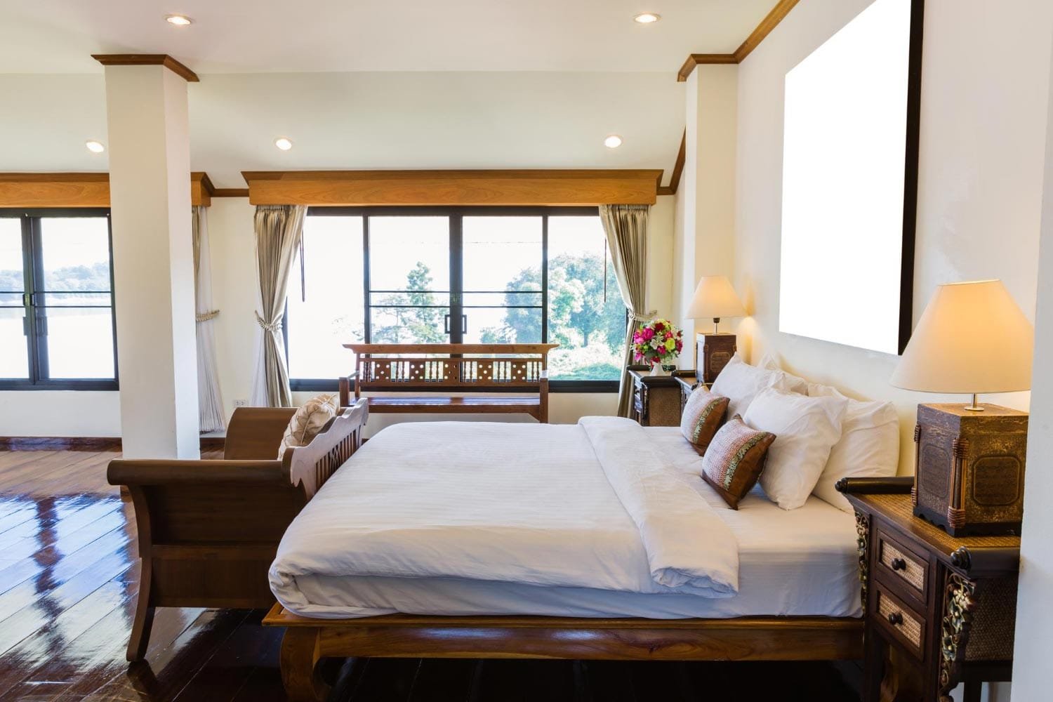 Luxury bedroom with wooden furniture in deluxe houseboats in Alleppey.