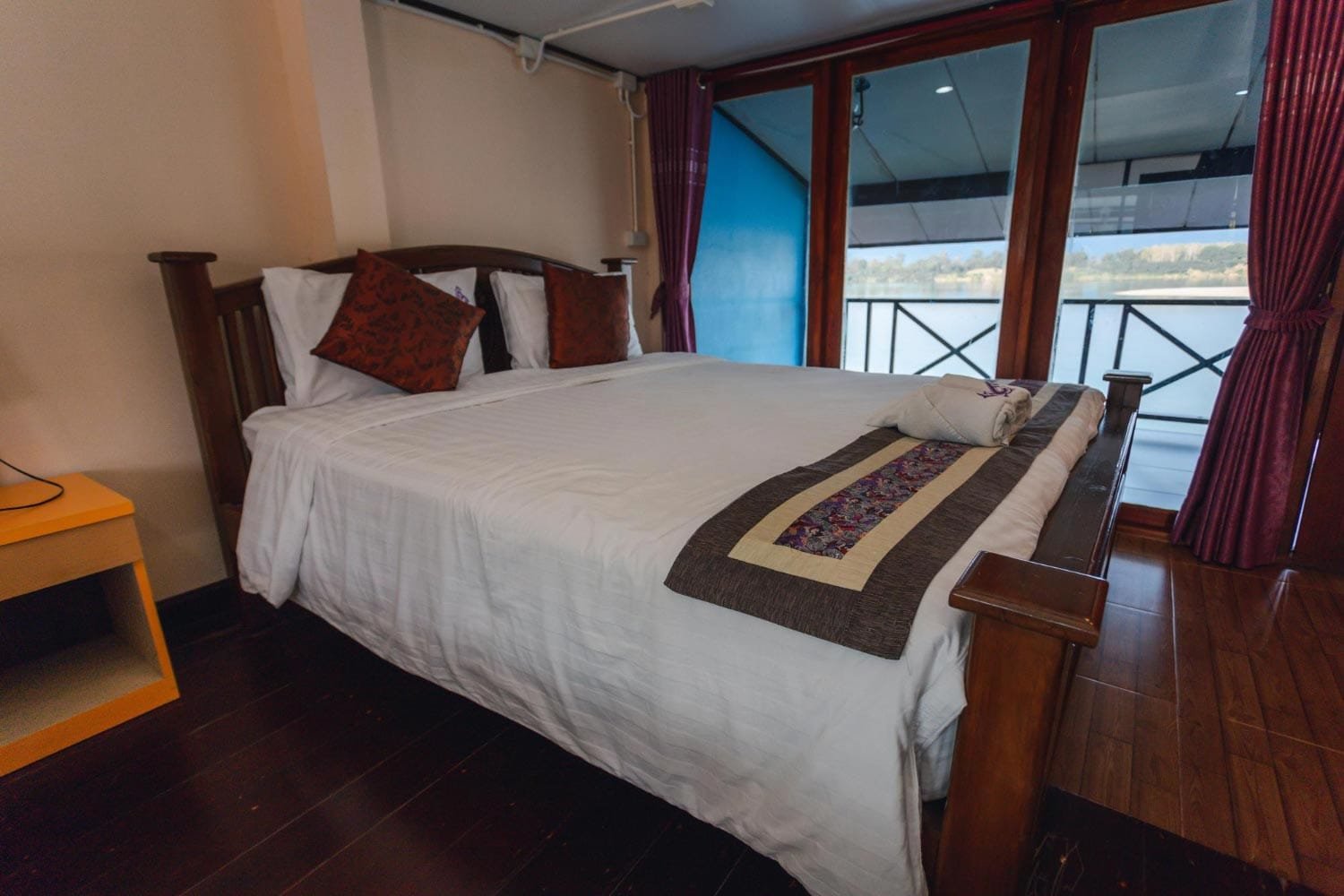 Cozy bedroom with wooden furnishings and glass doors